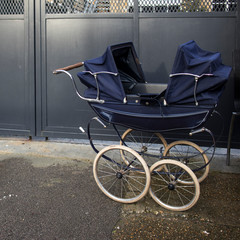 Fototapeta na wymiar Blue vintage twin stroller at flea market