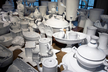 wide variety of plates bowls and mugs lined up for sale at the market.