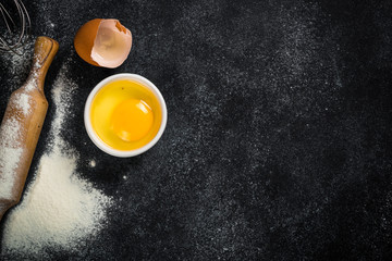 Fototapeta na wymiar Baking background on black with flour and eggs.