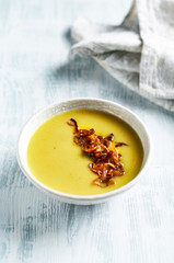 Cream of potato and leek soup with turmeric, topped with caramelized challots