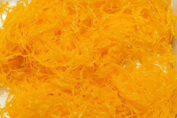 Foi thong or Shredded egg yolk tart or golden threads made from egg yolks of duck eggs. Simmer in boiling water and granulated sugar.
