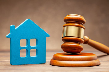House and judge gavel on brown background. The concept of selling a home cher auction or property section