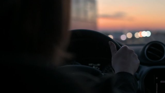 Woman driving car in dusk