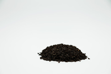 a handful of dried tea leaves sprinkled with a slide on a white background