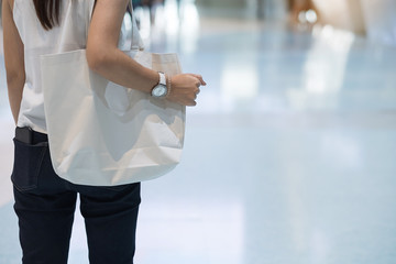 Woman hand holding Eco Shopping bag in store background with Copy space for text. Environmental Protection, Zero waste, Reusable, Say No Plastic, World Environment day and Earth day concept