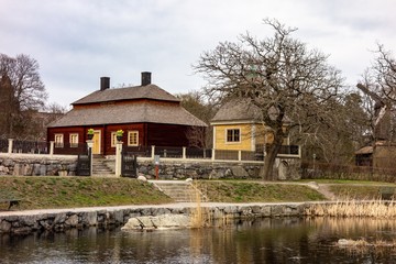 Fototapeta na wymiar Historic wooden houses and small lake in the Skansen in Stockholm, Sweden