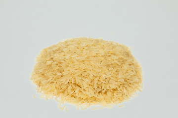 handful of rice poured in a slide on a white background
