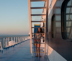 Asain teen in shorts, sandals and tube top framed by stairs with blue sky in the background