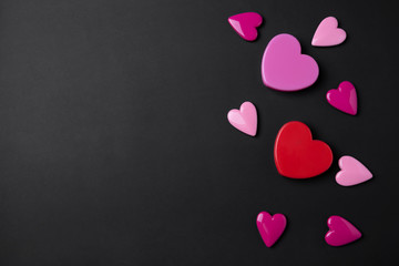 Valentines day background with pink and red hearts on black copy space background.