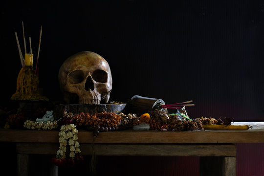 Old Skull and candle with incense on old altar plate  which has dim light