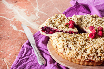 Homemade berry shortcrust pie with crumble on wooden board
