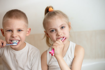 fair-haired cute funny children 7-9 years old brush their teeth