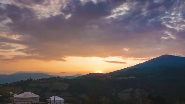 Time lapse of Wild Landscape at Sunset with Yurts on a Hill