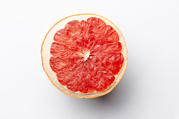 Slice of red dry grapefruit on gray background with shadow