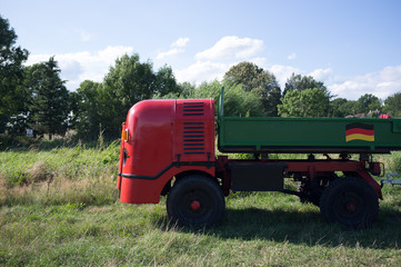 Obraz premium Red commercial vehicle in a meadow