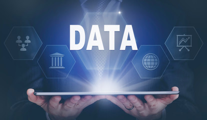 Businessman holding a computer tablet display projecting a Data concept.