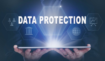 Businessman holding a computer tablet display projecting a Data Protection concept.