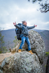 Traveller on the peak of high rocks in autumn. Sport and active life concept