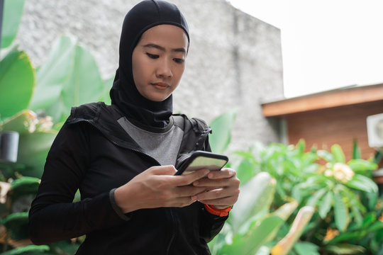 asian muslim women wearing hijab sportswear using smartphone when break after workout - Powered by Adobe