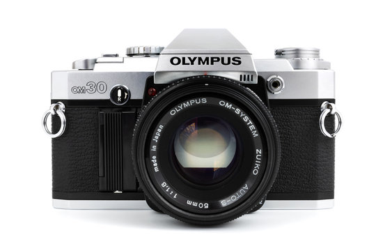 Prague, CZECH REPUBLIC - FEBRUARY 21, 2019: Olympus OM-30 a 35mm film SLR camera, launched by Olympus Corporation, laid on white background