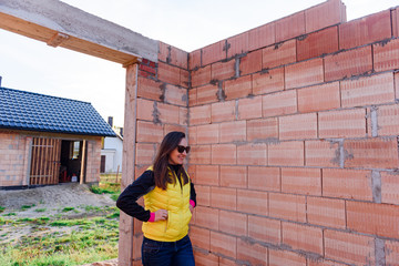 Fototapeta premium Interior of a Unfinished Red Brick House Walls under Construction without Roofing