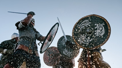 Warriors of vikings are fighting during attack at winter time.