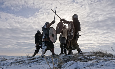 Warriors of vikings are fighting during attack at winter time.