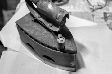 Antique Cast Iron Coal Iron. Workshop for restoration. Black and white tint, selective focus