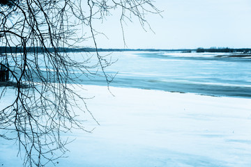 Fototapeta na wymiar Early spring drift on beautiful river with broken off pieces of ice float down the stream.