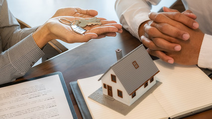 House model with agent and customer discussing for contract to buy, get insurance or loan real estate or property.
