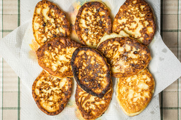 Curd cheesecakes on white napkin to absorb excess oil.