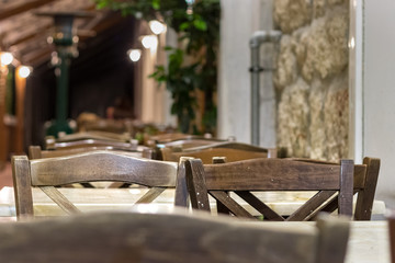 Wooden chairs and table outdoors on the street of a greek taverna.