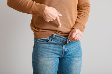 Young man with urologic disease on light background