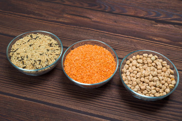 chickpeas, basmati rice and red lentils in a bowl. organic healthy cereals. on a wooden background. natural vegetarian vegetable protein . the view from the top. close-up of grain