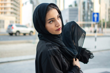 Portrait of beautiful middle eastern arab woman wearing abaya on the street