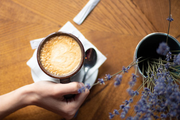Girl having coffee in cafe. Hand with coffee.