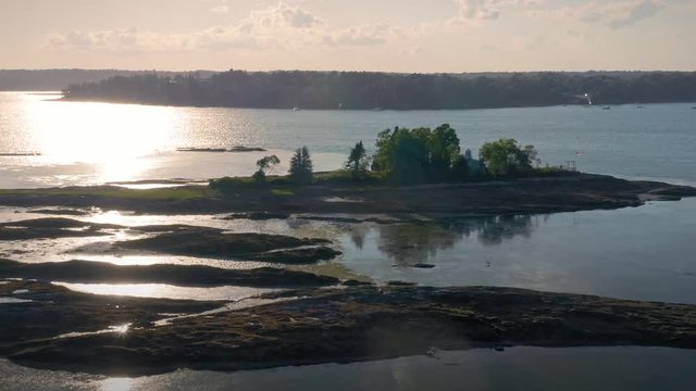 Aerial: Flying over a harbor & island at sunset. Orr's Island, Maine, USA