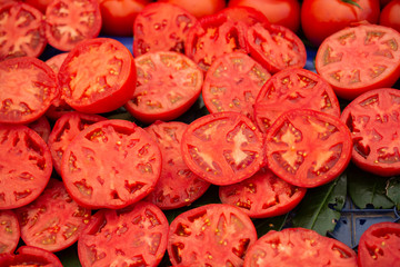 Ripe fresh delicious tomato vegetables cut in halves in bazaar market