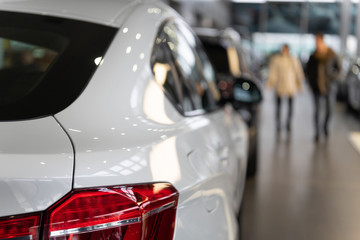 Naklejka premium Rear view of the part of a white luxury vehicle in a motor show. The concept of selling cars by dealers in a car dealership