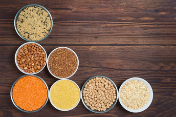 grains red lentils, basmati rice, buckwheat, chickpeas, millet in plates. organic healthy cereals. on a wooden background. natural vegetarian vegetable protein . the view from the top. close up