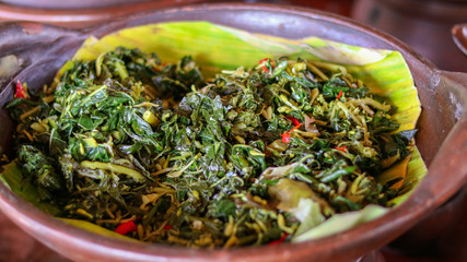 Traditional indonesian culinary food. Indonesian food Oseng oseng daun pepaya made from young Papaya's leaf, mix with spice, chilli, with topping ikan Teri, Salted fried tiny fish