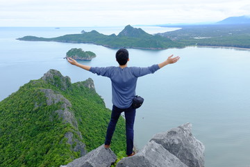 man on top of mountain front sea