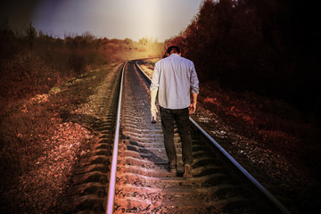 Man with alcohol on railway tracks outdoors. Travel concept. Lonely person. Suicide concept....