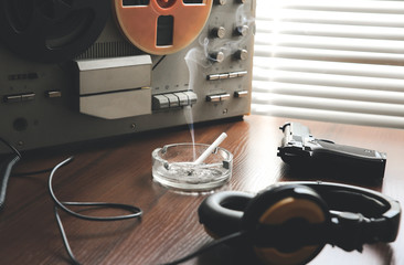Reel tape recorder for wiretapping. KGB spying conversations. Black gun nearby. Ashtray with a...
