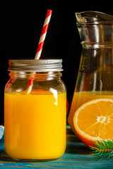 glass jar of fresh orange juice with fresh fruits on wooden table