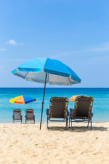 Relaxing on the beautiful beach, summer outdoor day light, holiday and vacation destination, beach chair with colorful umbrella over blue sea background