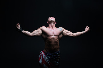 Fototapeta na wymiar Athletic male bodybuilder on a dark background. A man with a beautiful body.athlete, exercise, health, power, strength, man,
