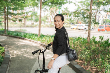 Fototapeta na wymiar woman worker ready to ride her folding bike go to office