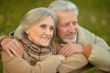 Smiling senior couple embracing in autumn park