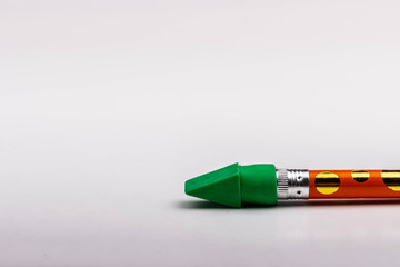 A Green Eraser on a Yellow and Gold Polka Dot Pencil
